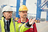 Dock worker and manager talking at shipyard