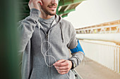 Male runner listening to music with headphones
