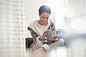 Smiling woman in pyjamas reading book