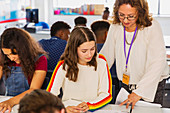 Female teacher helping student doing homework in classroom