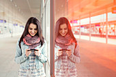 Young woman using smart phone in train station
