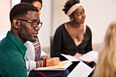 Attentive, businessman with paperwork listening in meeting