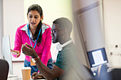 Instructor helping student at computer in computer lab