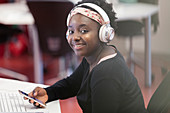Portrait college student and headphones in classroom