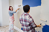 Happy couple painting wall