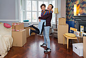 Portrait happy, playful couple moving into new house