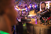 Bartender pouring cocktails at garden party