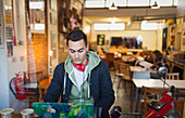 Focused college student studying at laptop in cafe window