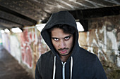 Portrait menacing young man in urban tunnel