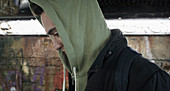 Serious young man wearing hoody in urban tunnel
