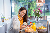 Smiling woman with digital tablet baking in kitchen