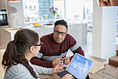 Couple financial planning at digital tablet in kitchen