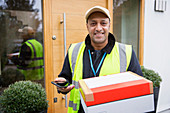 Deliveryman with package and smart phone at front door