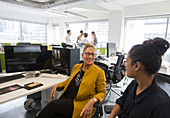 Businesswomen talking in open plan office