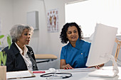 Doctor meeting with senior patient at computer