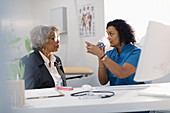 Doctor teaching senior patient how to use inhaler