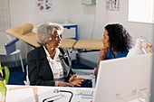 Doctor talking with senior patient in doctors office