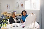 Doctor meeting with senior patient at computer