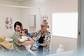 Paediatrician examining baby girl in examination room