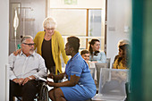 Female nurse talking with patient in wheelchair