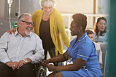 Female nurse talking with patient in wheelchair