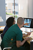 Nurses discussing digital x-ray at computer in clinic