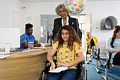 Woman pushing girl in wheelchair in clinic