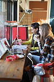 Young female college students studying in cafe window