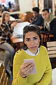 Portrait upset young woman with smart phone in cafe