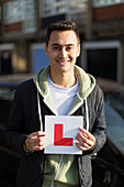 Portrait happy, young man holding learner permit