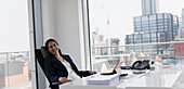 Portrait happy, businesswoman working in highrise office