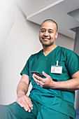 Portrait male surgeon using smart phone
