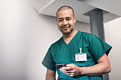 Portrait confident, male surgeon using smart phone