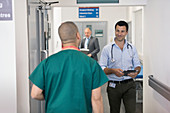 Male doctors greeting, passing each other
