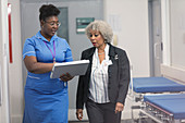 Doctor and nurse discussing medical chart, making rounds