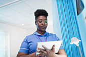Female nurse using digital tablet in hospital room