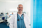 Portrait confident, male doctor in hospital room