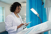 Female doctor using digital tablet in hospital room