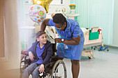 Female nurse pushing boy patient in wheelchair