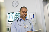 Portrait confident, male doctor using tablet in hospital