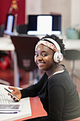 Portrait female student with headphones and smart phone