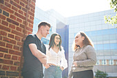 College students talking outside sunny building