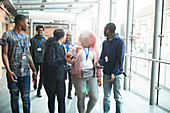 High school students talking and walking in corridor