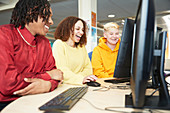 College students studying together at computer in library