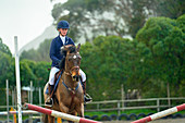 Teenage girl equestrian jumping