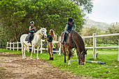 Girls preparing for horseback riding lesson