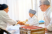 Chef helping students with Down Syndrome in baking class