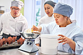Young woman with Down Syndrome learning to bake in kitchen