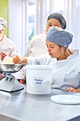 Young woman with Down Syndrome measuring muffin mix