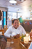 Portrait woman with Down Syndrome in cafe with friends